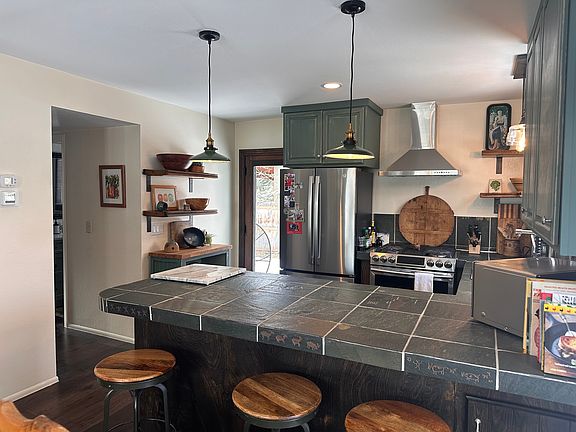 kitchen that opens to back deck as well as a side deck with small table for coffee