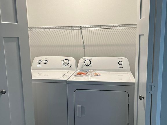 Washer and dryer and located in their own area with bifold doors to close off.