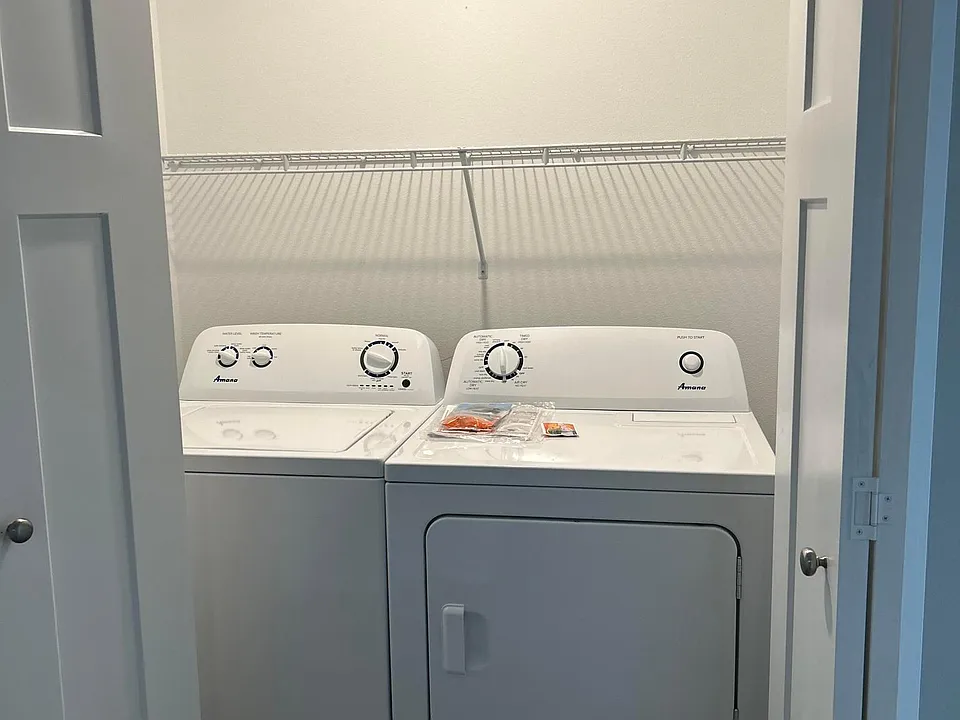Washer and dryer and located in their own area with bifold doors to close off.