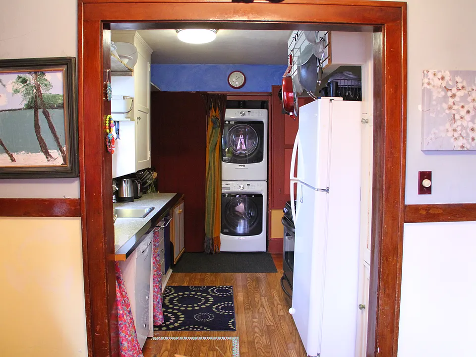 Looking into kitchen. Gas stove full size fridge.