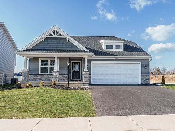 Front view of gray ranch with white trim, stone base, and attached two-car garage