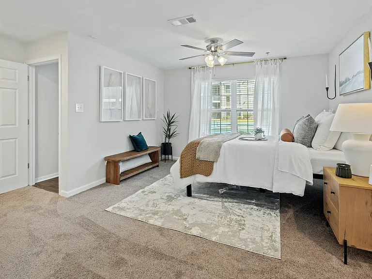 Spacious Bedroom with Carpets, Ceiling Fan, and Nook at Theater Street Apartments