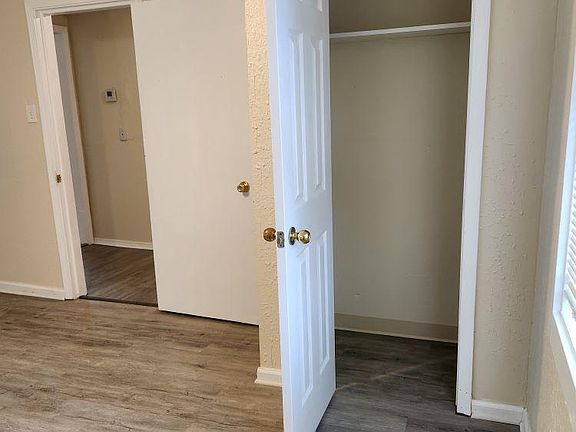 Bedroom with closet and window looking outside to backyard.