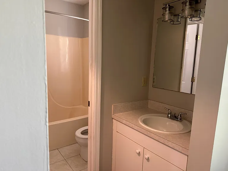 Bathroom off master bedroom has a single sink and the toilet and shower has a door to close. New flooring to be installed 10 July.