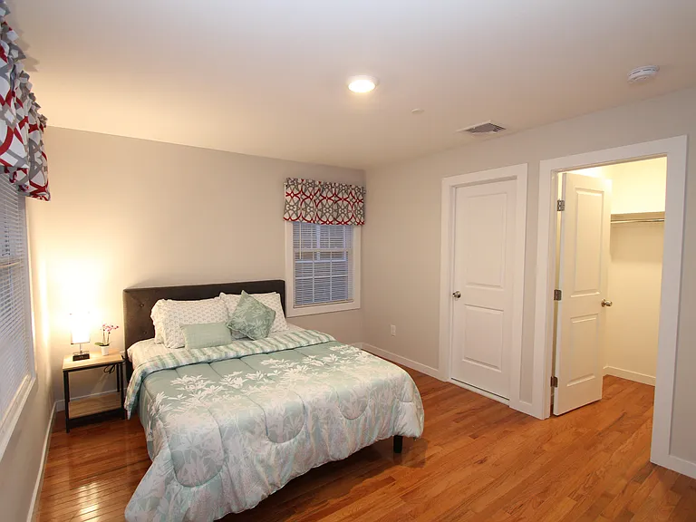 Bright bedroom with hardwood floors and ample closet space