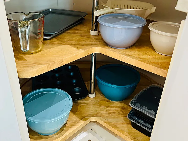 Metal cooking trays, bowls with storage lids, cupcake bakeware, strainer and measuring cup, etc.