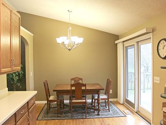 Newer light fixture in dining room high lights the vaulted ceiling beautifully. Patio doors walk out to a large deck.
