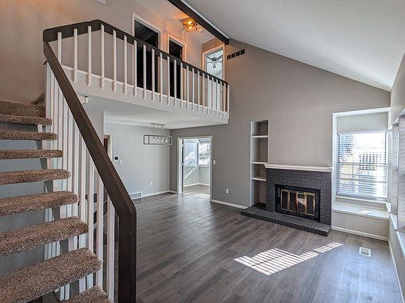 Spacious main room with vaulted ceiling and fireplace.