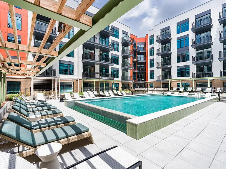 Resort-style pool with in-water loungers, shaded seating, and a spacious sundeck for warm-weather relaxing.