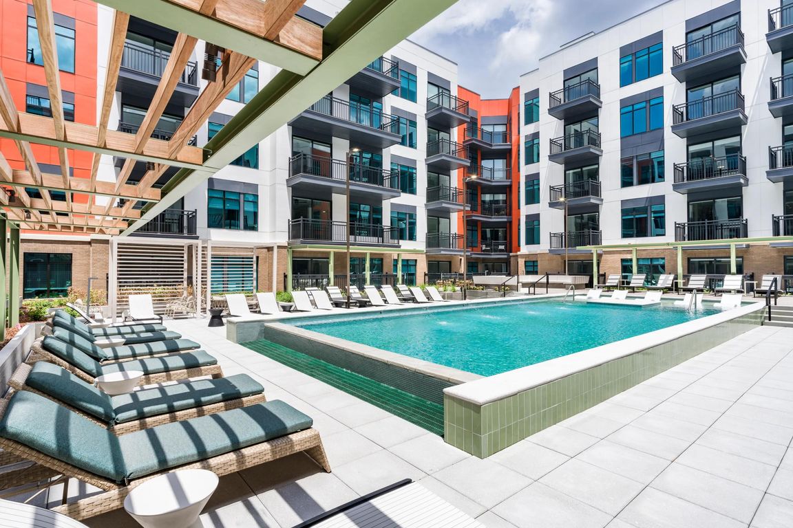 Resort-style pool with in-water loungers, shaded seating, and a spacious sundeck for warm-weather relaxing.