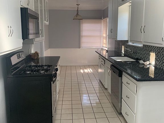 Galley Kitchen with Granite Counter Tops & New Stainless Steel Appliances