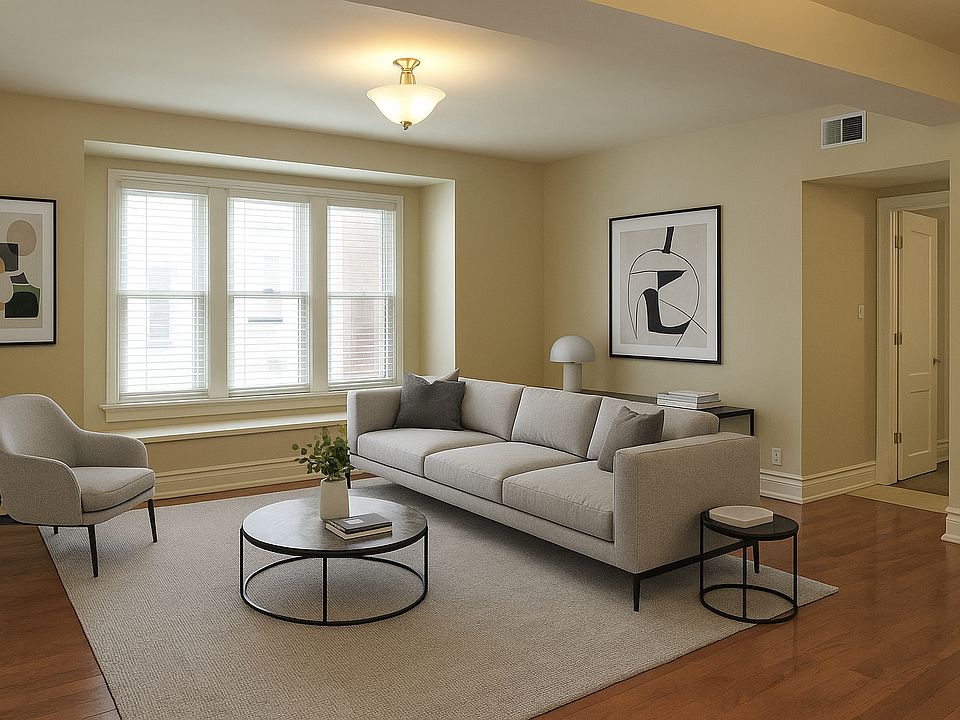Spacious living area with gleaming hardwood floors and an abundance of windows. (virtual staged)