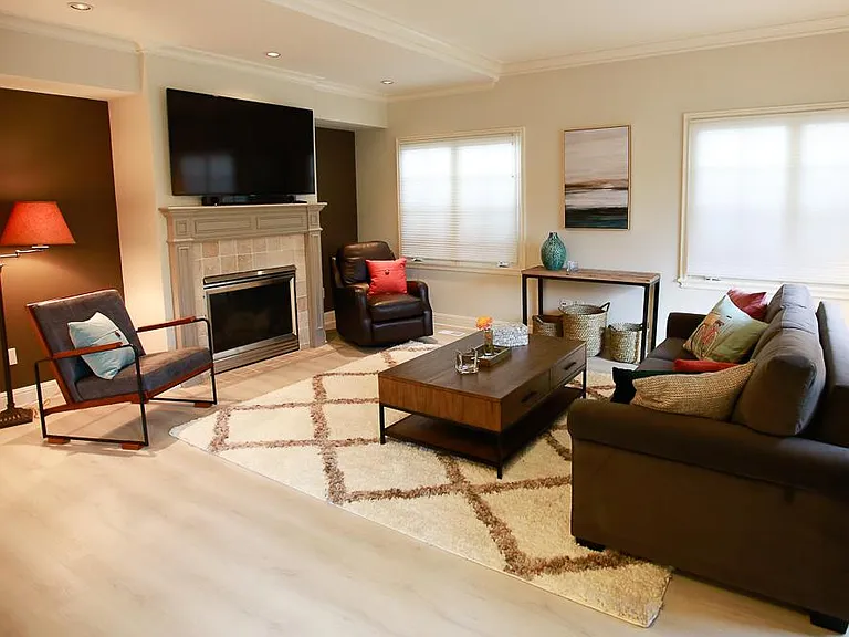 Living room area facing cozy gas fireplace and large mounted TV with a nice internet TV package through Hulu.