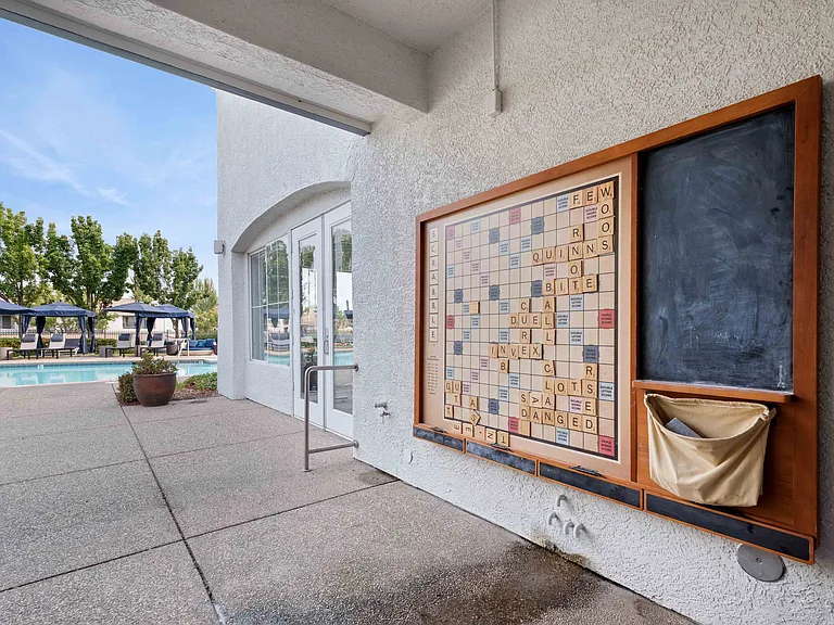 Our pool deck features a sparkling pool, plenty of lounge seating, a covered fire pit lounge, and a life-size Scrabble boardperfect for friendly neighbor fun and relaxing under the trees.