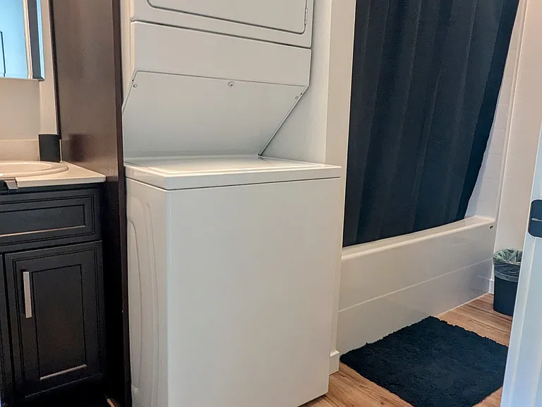 Full bath and shower with stacked washer and dryer. Starter supply of shampoo, conditioner, hand soap, shower gel and toilet paper.