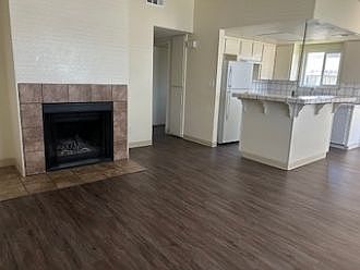 Living room with fresh paint, vinyl plank floor, and wood-burning fireplace