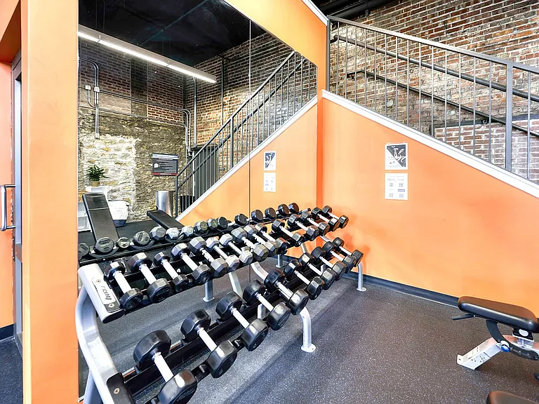 Free weghts, large mirror, stairs coming into fitness center