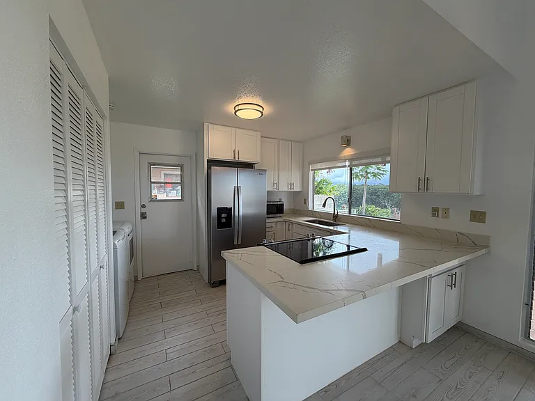 Recently updated kitchen with newer cabinets, countertops, and appliances. Large pantry for additional storage. Views from kitchen window.