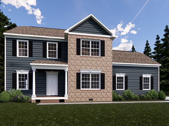 The Rowland is a charming two-story house in Poplar Village, featuring dark siding, a brick section,
