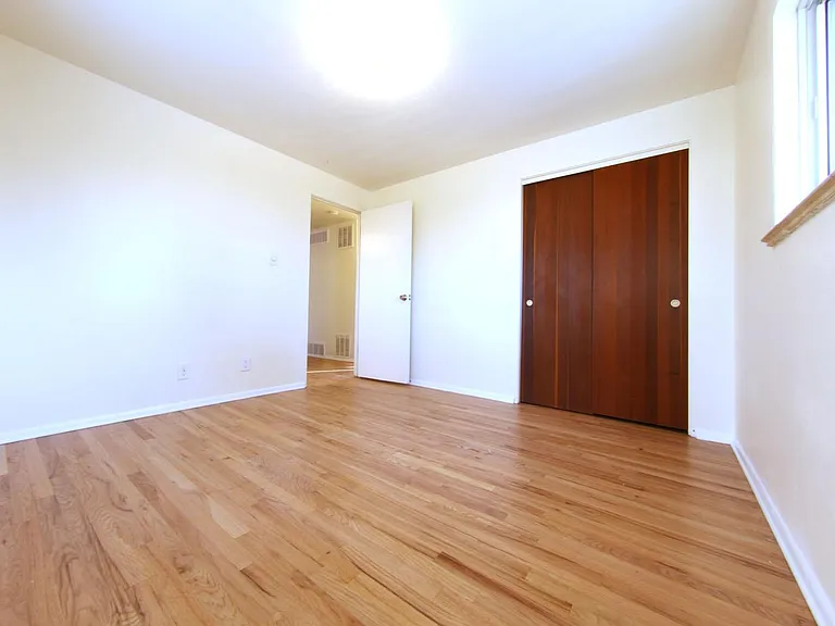 Large bedroom #1 with Teak closet doors and ample windows.