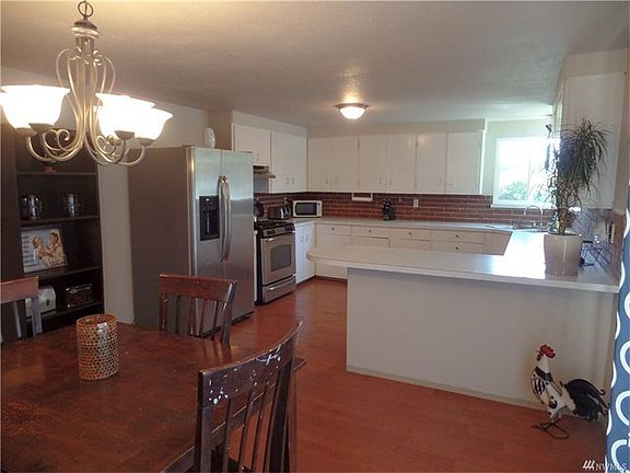 Large eat-in kitchen with laminate flooring, gas range, lots of counter space and door leading to deck and rear yard.