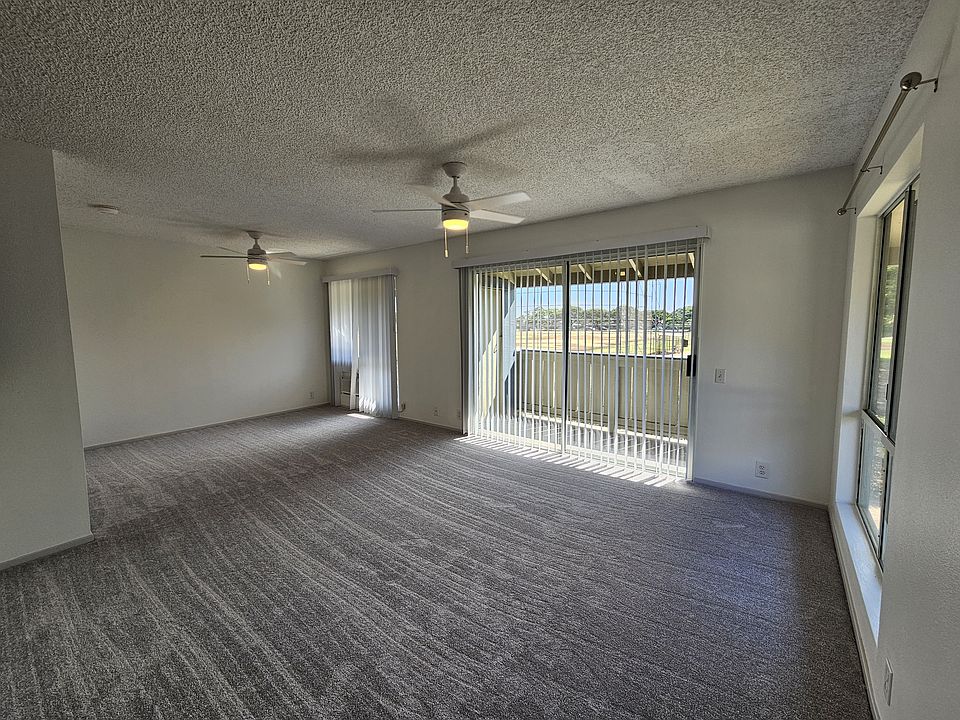 Living area with new gray carpet and new thick pad so noise to neighbors below is minimal. Two new ceiling fans. New 14000 BTU A/C.