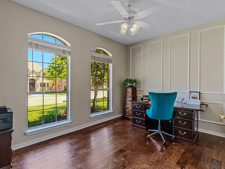 Rich wood-finish flooring complements the wall paneling and trim work in this space