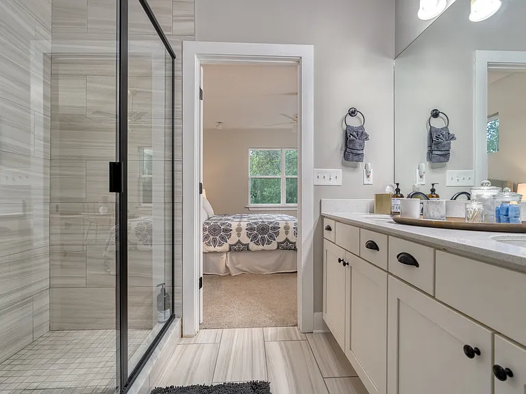 Master en-suite elegance. This spacious full bathroom features a sleek, glass-enclosed walk-in shower and a double vanity designed for effortless morning routines