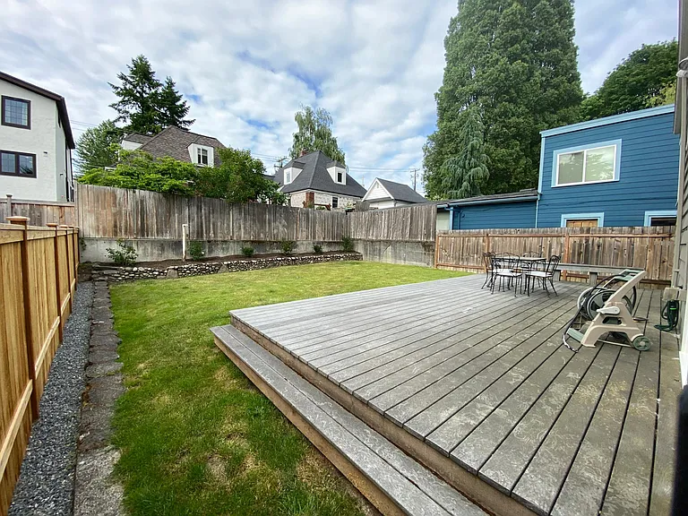 Fenced backyard with large deck and lawn
