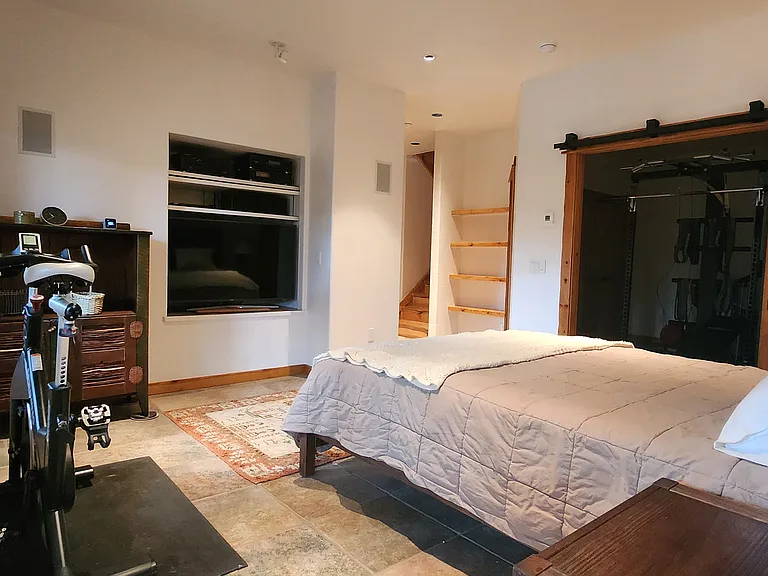 Large downstairs bedroom looking to closets and gym area