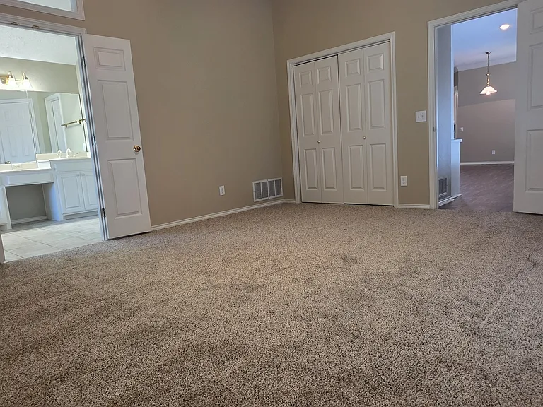 MASTER BEDROOM LOOKING TO MASTER BATH ON LEFT, DOUBLE CLOSET IN CENTER, BEDROOM TO LIVING AREA ON RIGHT