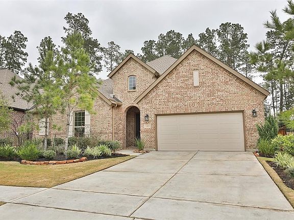 Lovely landscaping and mature trees in the natural area behind the home