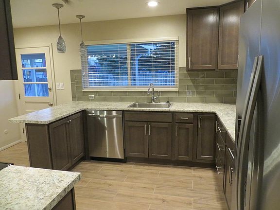 Kitchen & door to back yard next to bar seating