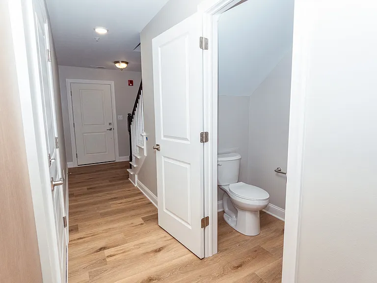 Half bath in hallways heading towards entrance