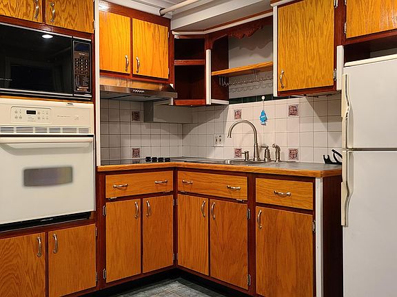 Kitchenette with electric stovetop and hood