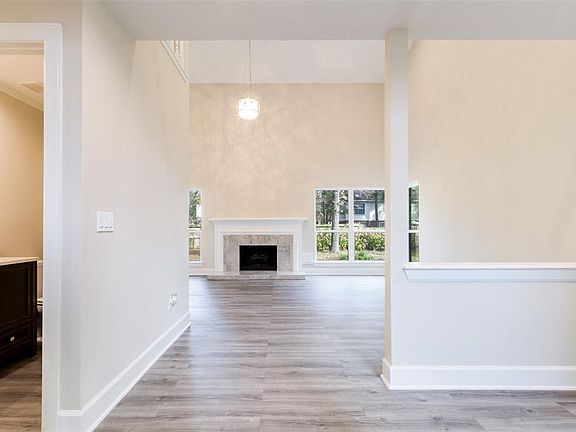 Looking into the Fabulous Great Room from the Foyer! Fresh Neutral Paint, New Fireplace surround, New Wood Look Tile Flooring, New Chandelier, All New Windows!