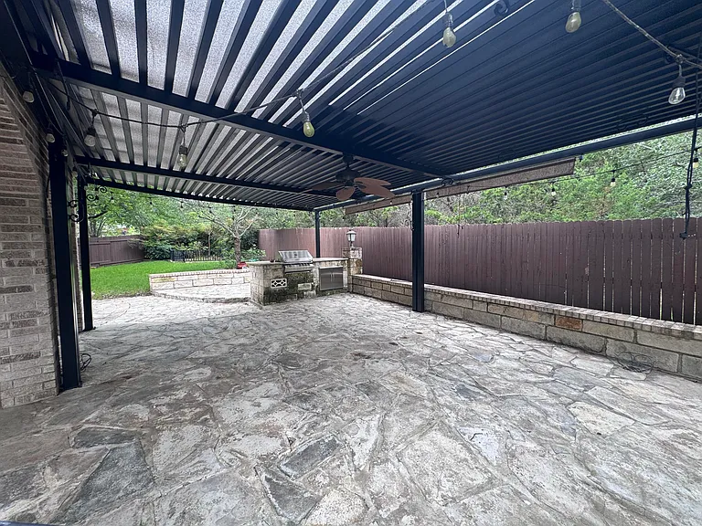Large covered patio with pergola and built in grill.