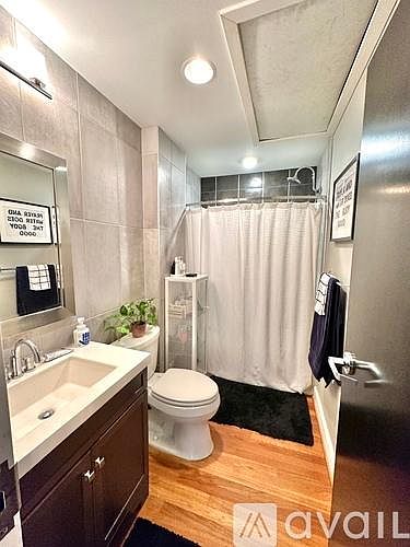 Primary Bath with tub/shower combo, rain shower head and tile accent wall