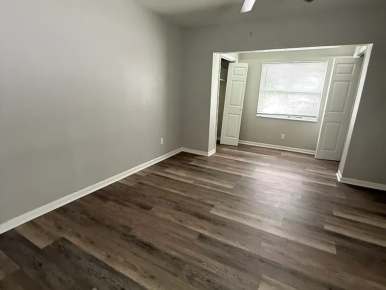 Master bedroom with bifold doors on each closet (left and right of the window)