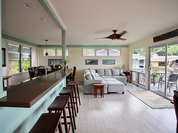Bright, open living area, newly renovated kitchen & luxury vinyl plank flooring, opening to lanai and fabulous view of ocean and mountains!