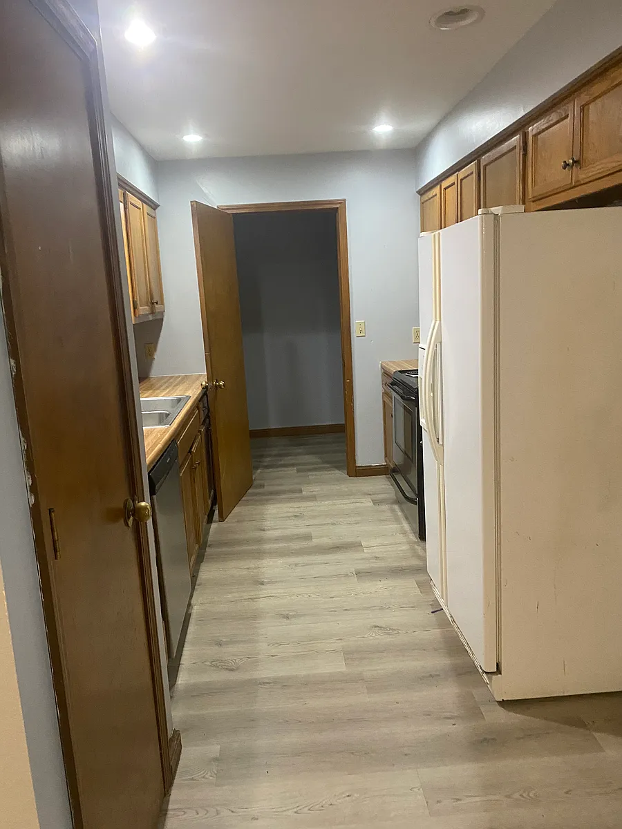 Kitchen leading into laundry. Includes pantry, dishwasher, stove, new microwave, refrigerator - 207 W Edgewood St