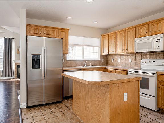 The kitchen has an island with storage, a brand new refrigerator/freezer, and a brand new dishwasher. The primary living space is an open concept and flooded with natural light.