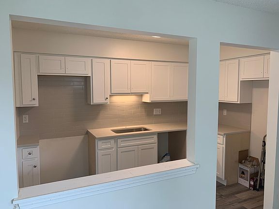 The kitchen has quartz countertops and a tile backspaslh.