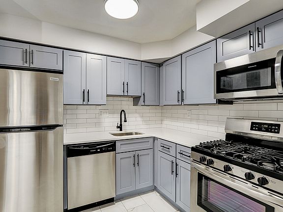 Experience culinary elegance in this modern kitchen, equipped with sleek appliances and ample storage.