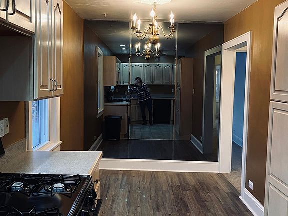 Dining area with wall of smoke beveled mirrors. Chandelier.