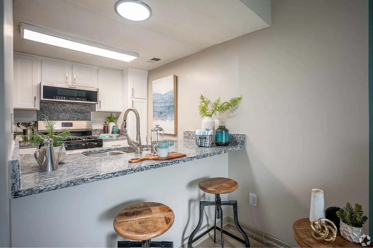 Bright kitchen with modern cabinetry and granite counters - The Manning Apartment Homes