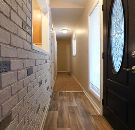 New front door/window, vinyl on floor, freshly painted brick wall.