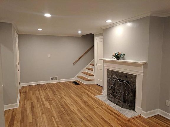 WELCOMING LIVING ROOM WITH HARDWOOD FLOORS, SOFT GRAY PAINT TONE, & GAS FIREPLACE.