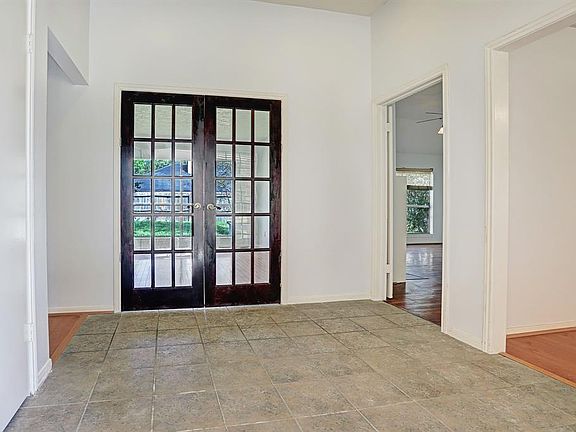 Step inside to find a foyer with tile floors, neutral paint, a raised ceiling, and a peek at the formal dining room, family room, and formal living/study or flex space.