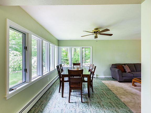 Dining room surrounded by huge windows and partial lake view